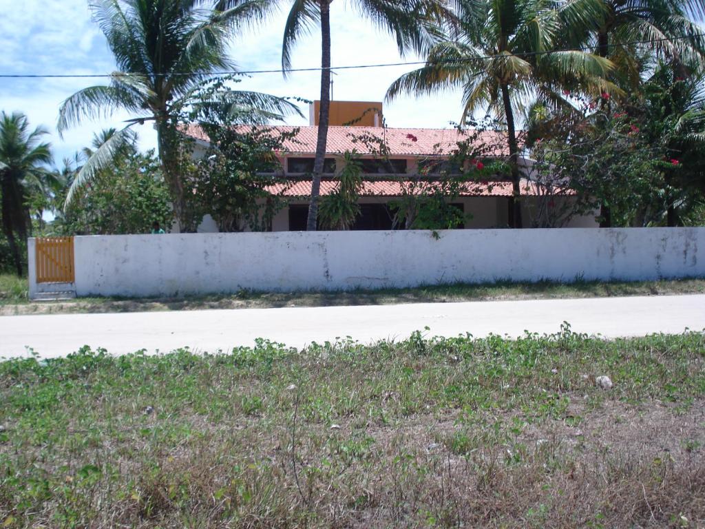 a house on the side of a road with palm trees at Recanto a ver o Mar in Sirinhaém