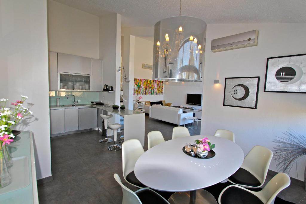 a dining room and kitchen with a white table and chairs at Marina Parque 83 - Clever Details in Vilamoura