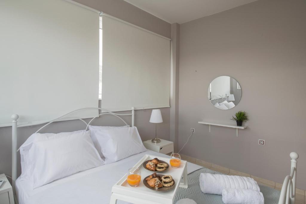 a white bed with a tray of food on a table at Angel-kolymvari4you in Kolymvari