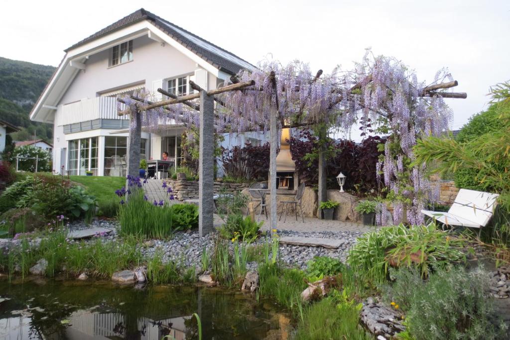 a house with a garden and a pond at BnB Villa Levanta in Péry