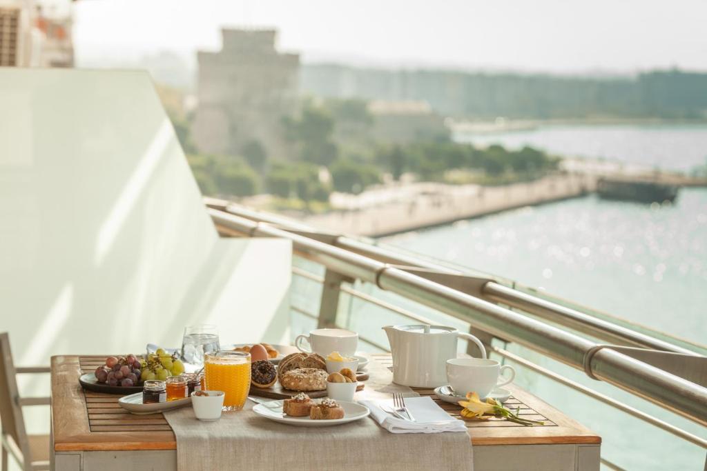 a breakfast table with food and drinks on a balcony at Daios Luxury Living in Thessaloniki