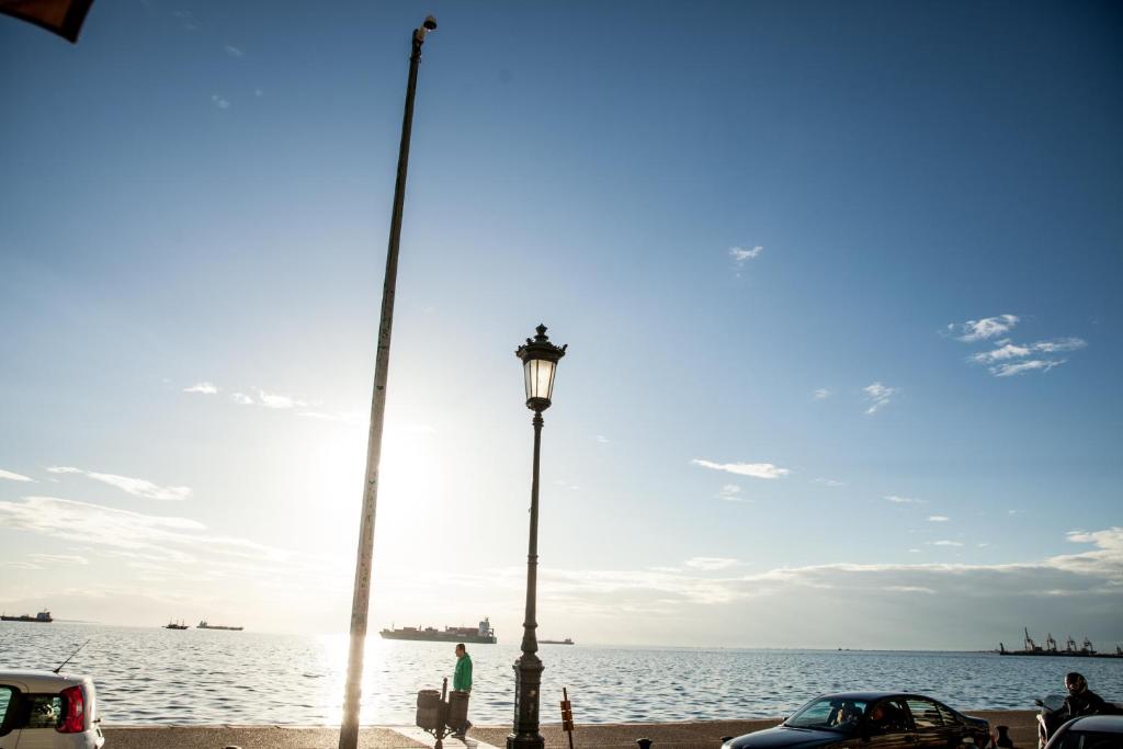 a person standing next to a street light next to the water at Daios Luxury Living in Thessaloniki