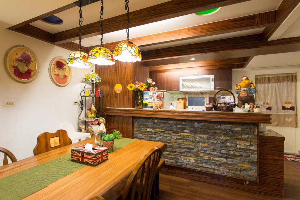 a dining room with a table and a kitchen at British Country Inn B&amp;B in Luodong