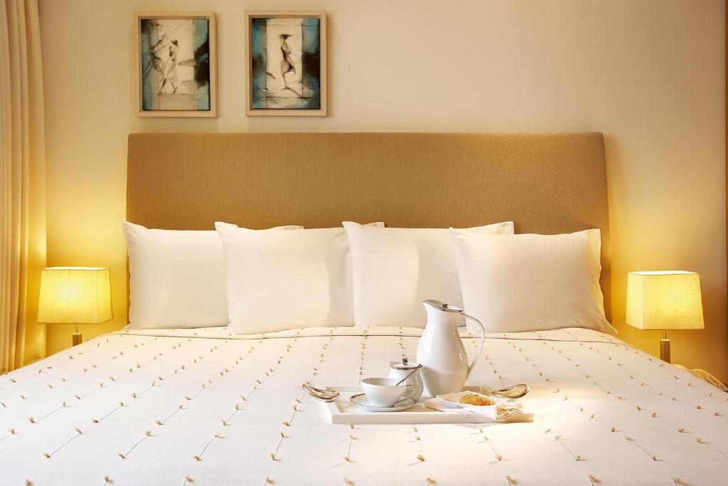 a hotel room with a bed with a tea set on it at Daios Luxury Living in Thessaloniki