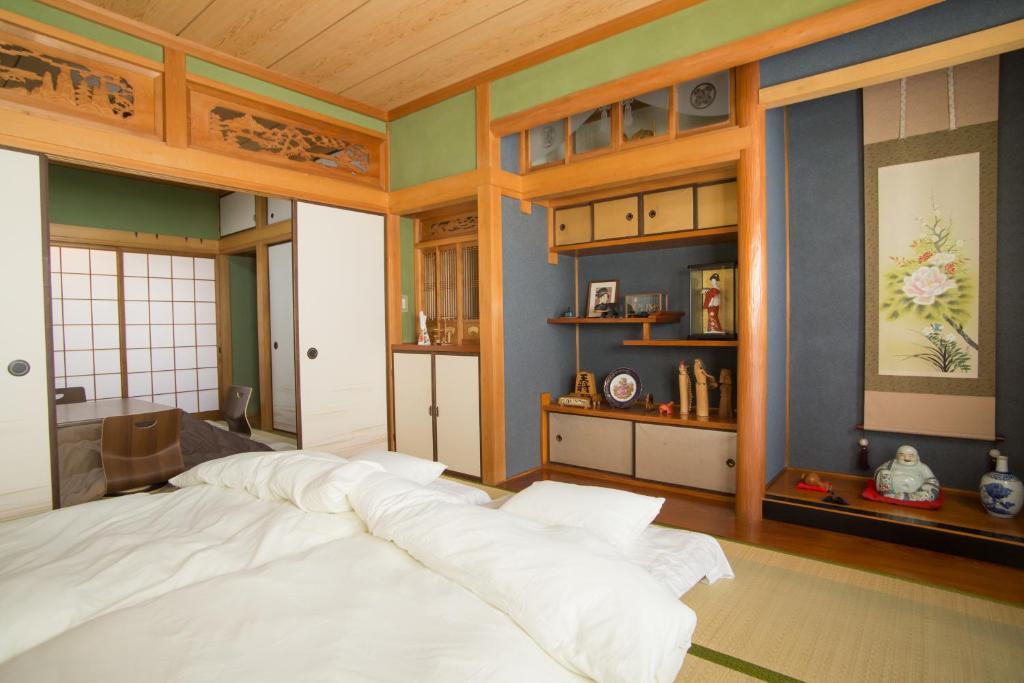a bedroom with a large white bed in a room at Guest House DOUGO-YADO in Matsuyama