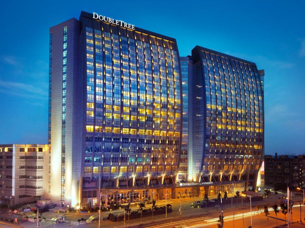 a tall building with a sign on top of it at DoubleTree by Hilton Shenyang in Shenyang