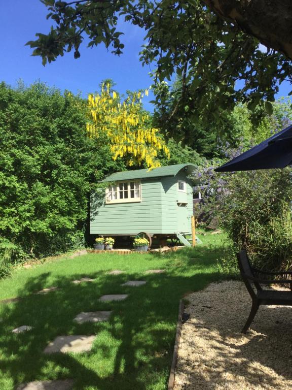 un cobertizo verde en medio de un patio en Cherryberry Lodges, en Abergavenny