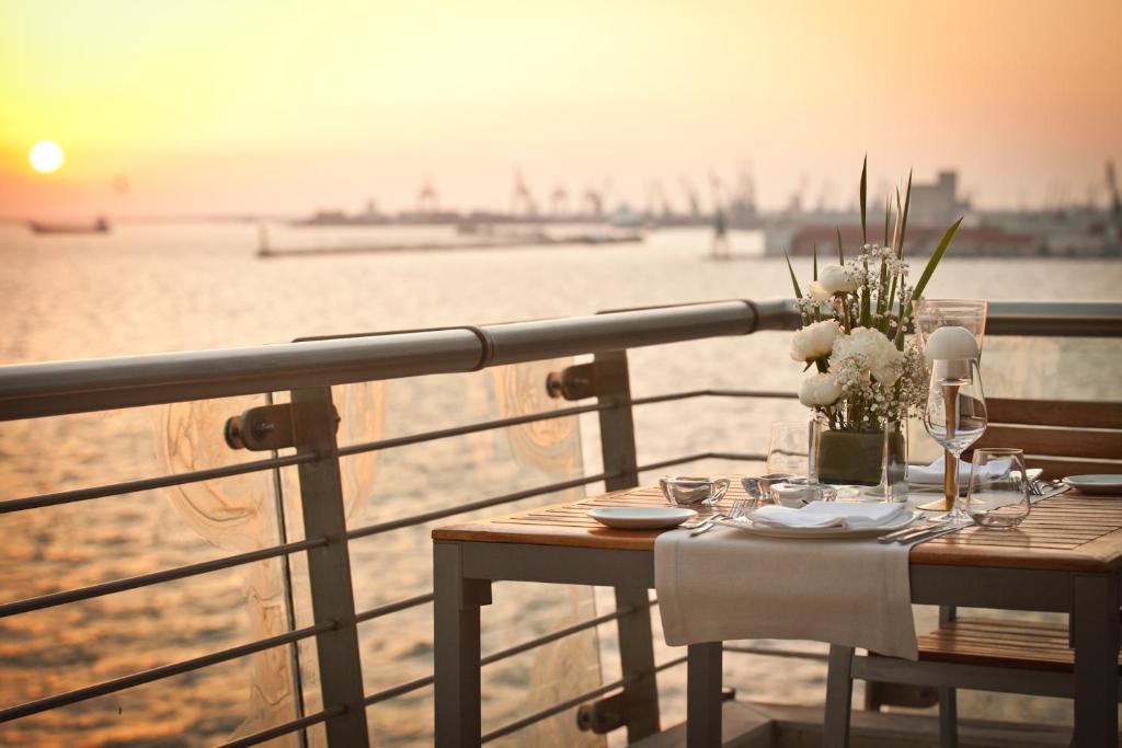 a table on a balcony with a view of the ocean at Daios Luxury Living in Thessaloniki