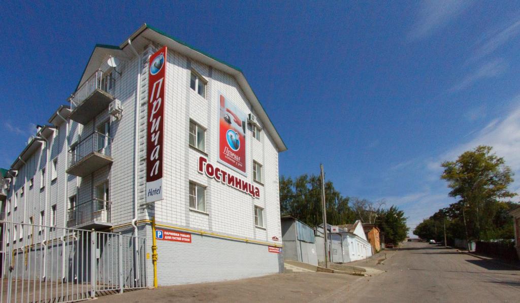 a large white building with a sign on the side of it at Prichal Hotel in Kaluga