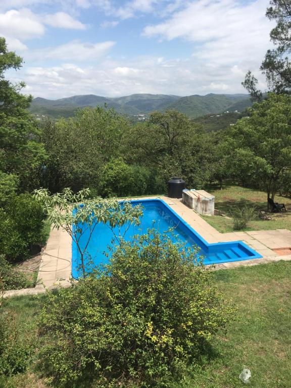 una piscina azul en un patio con árboles en Villa Anedé en Río Ceballos