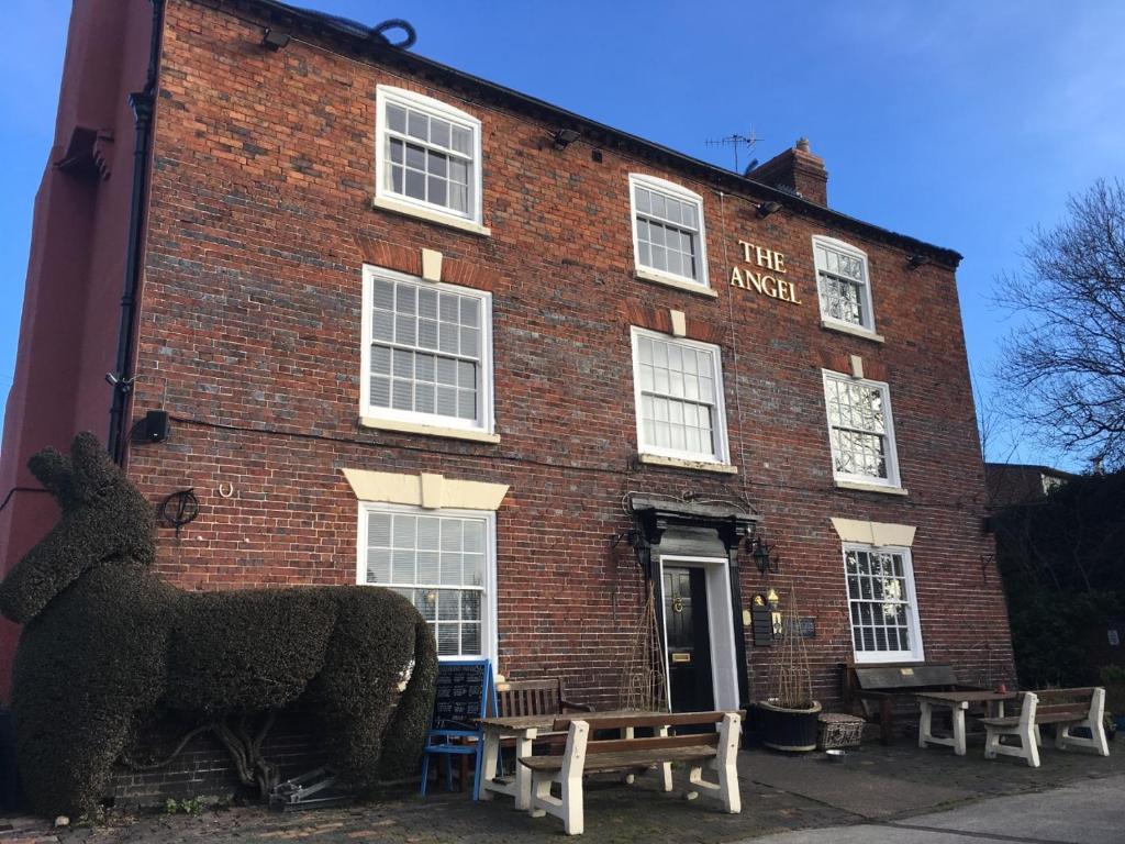 un edificio de ladrillo con dos estatuas de ovejas delante de él en The Angel Inn Stourport en Stourport