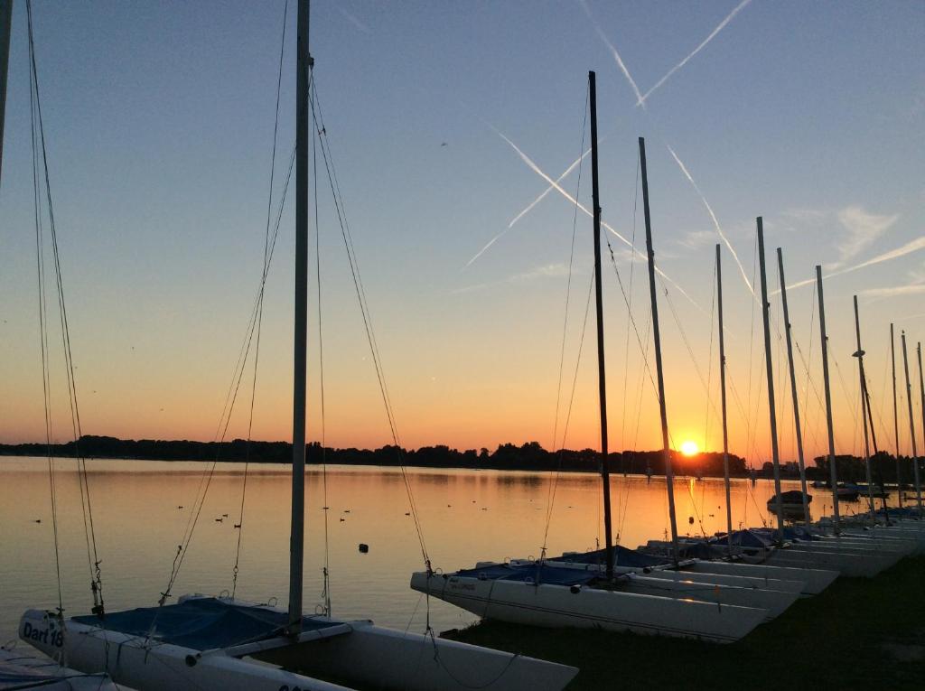 a row of sailboats in the water at sunset at 't Anker in Elburg