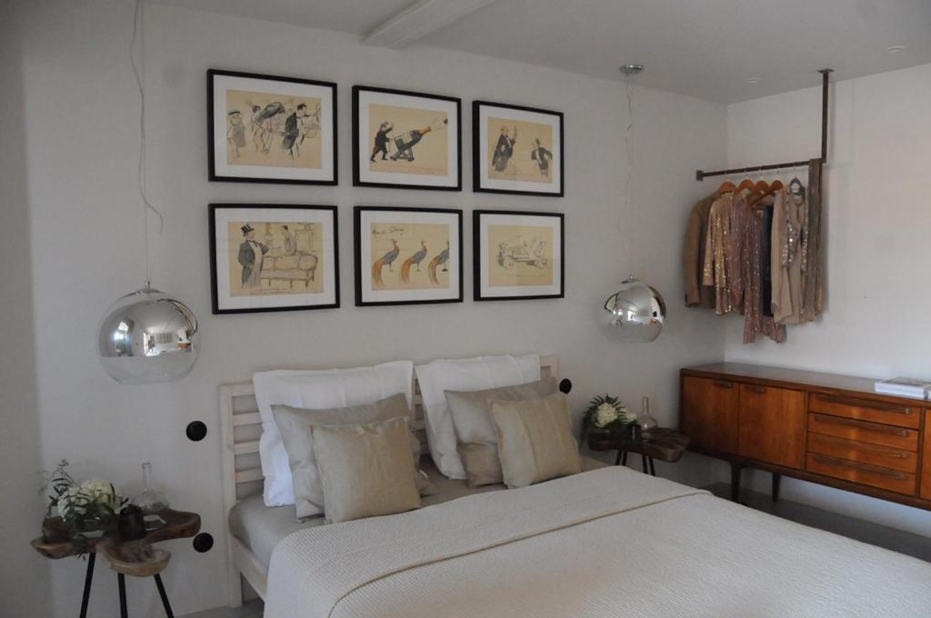 - une chambre avec un lit et des photos sur le mur dans l'établissement Campo de Santa Clara 98, à Lisbonne