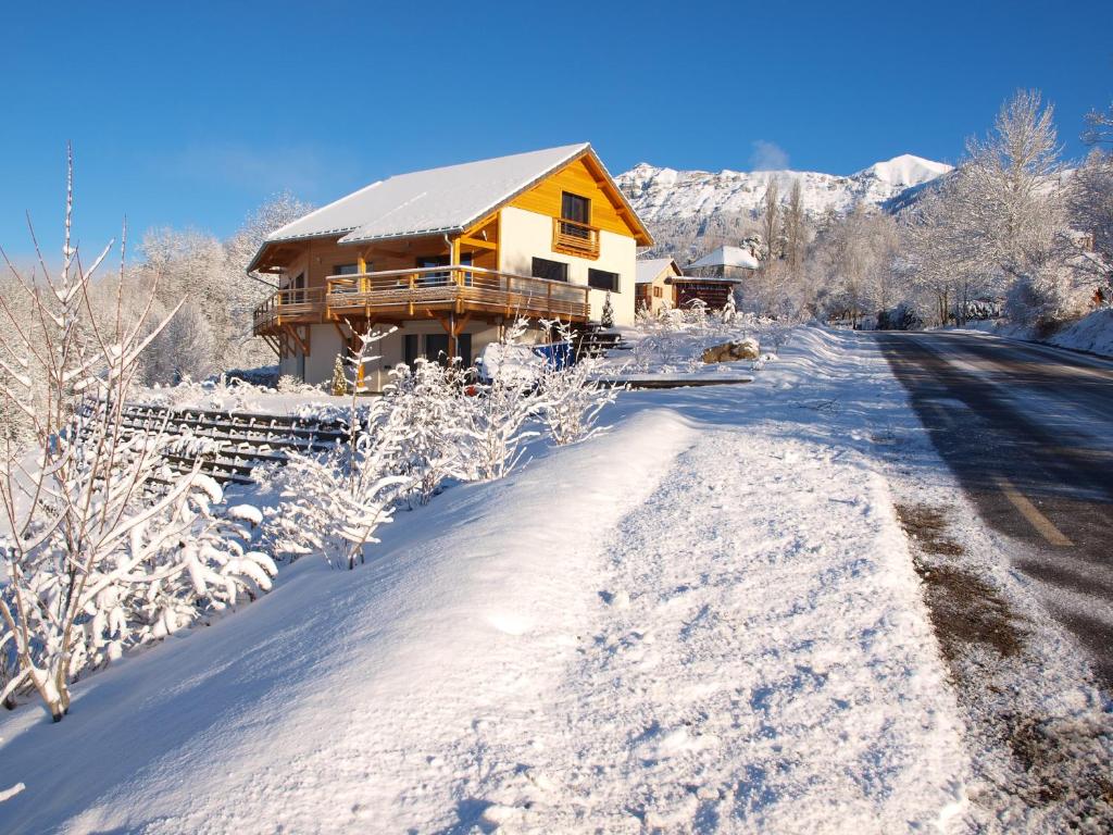 una casa cubierta de nieve junto a una carretera cubierta de nieve en Au Chant du Riou, en Saint-Michel-de-Chaillol