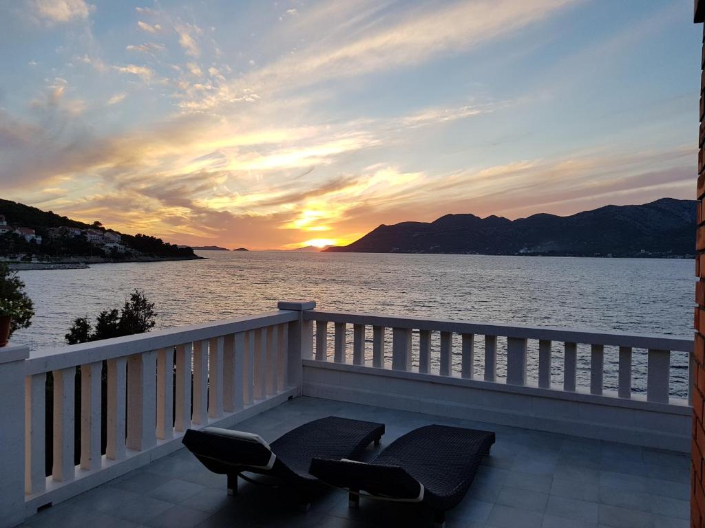 a balcony with chairs and a view of the water at Sunset Apartments in Korčula