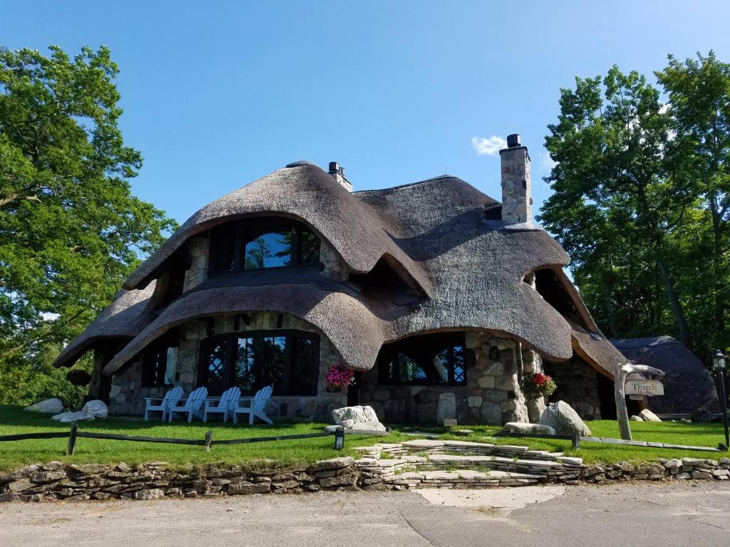 a home shaped like a house with chairs in front at The Mushroom Houses in Charlevoix