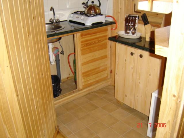 a small kitchen with a sink and a counter at Domki " ELRINO " in Jastarnia