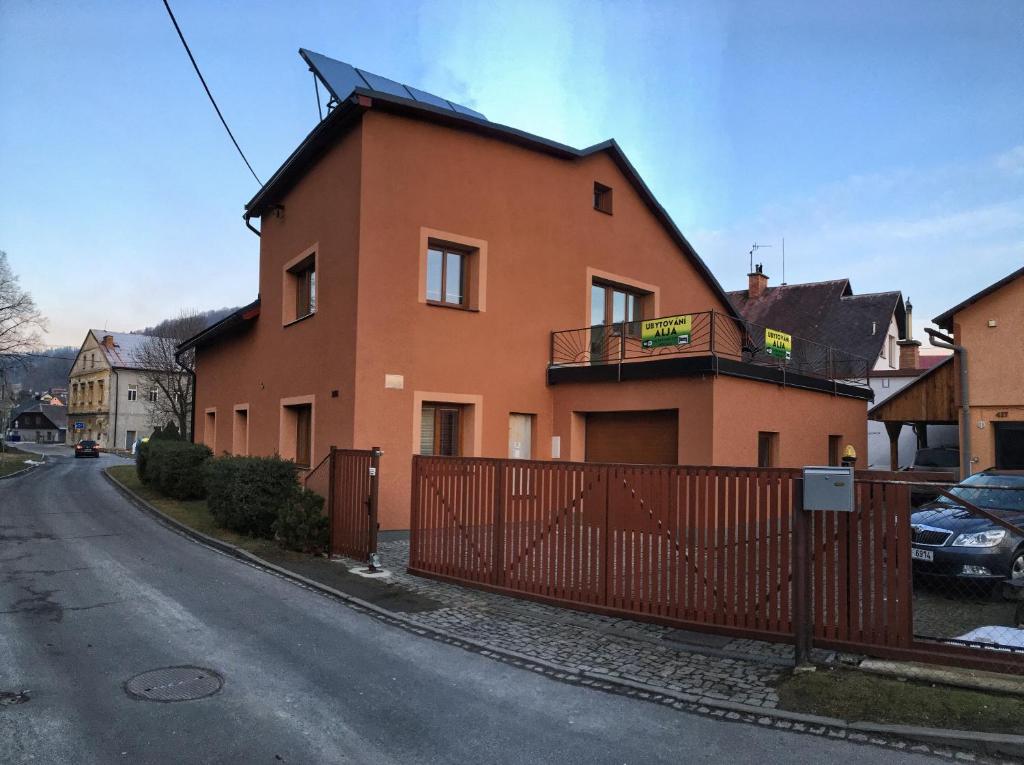 a brown house with a fence on a street at Ubytování ALJA in Jeseník