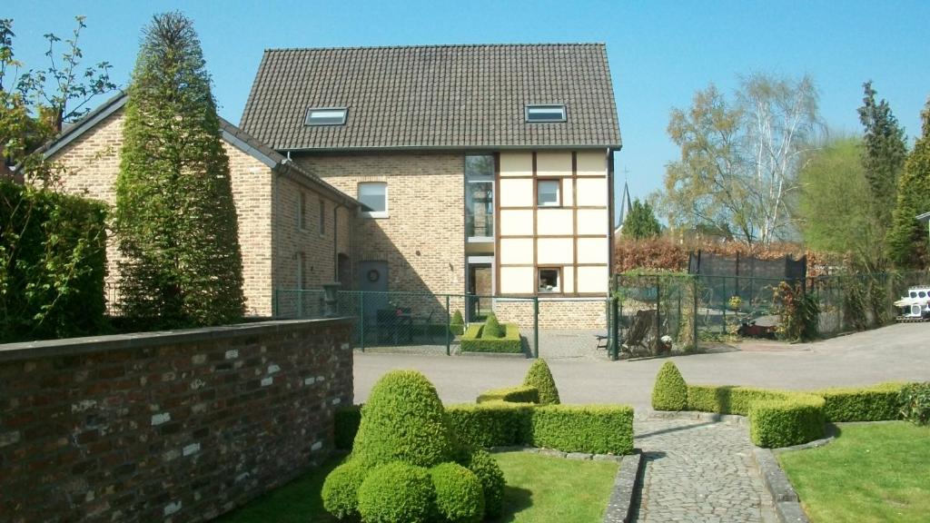 una casa con siepi di fronte a un edificio di 'tMaelhof a Voeren