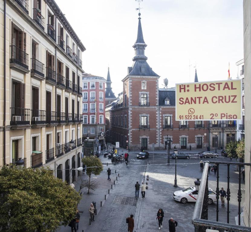 a group of people walking down a city street at Hostal Santa Cruz in Madrid