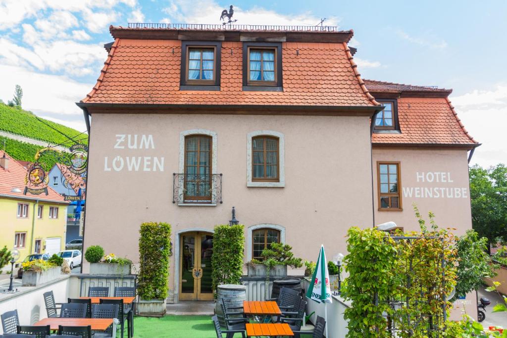 a building with tables and chairs in front of it at Hotel Löwen in Randersacker