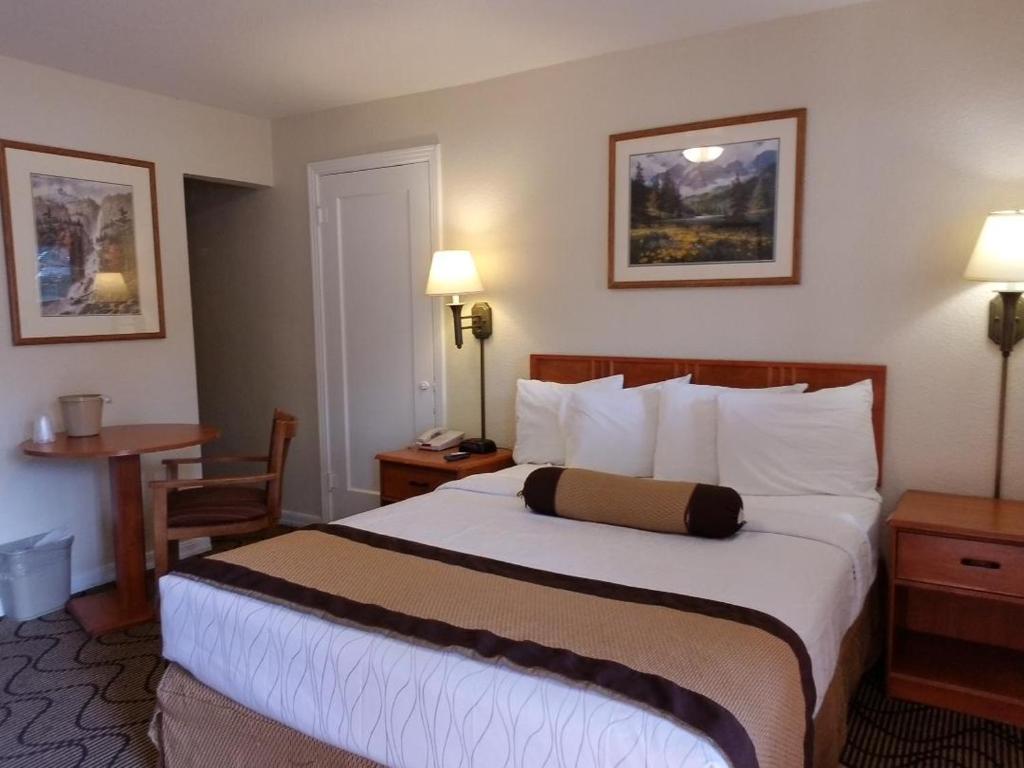 a hotel room with a large bed and a desk at Nevada City Inn in Nevada City