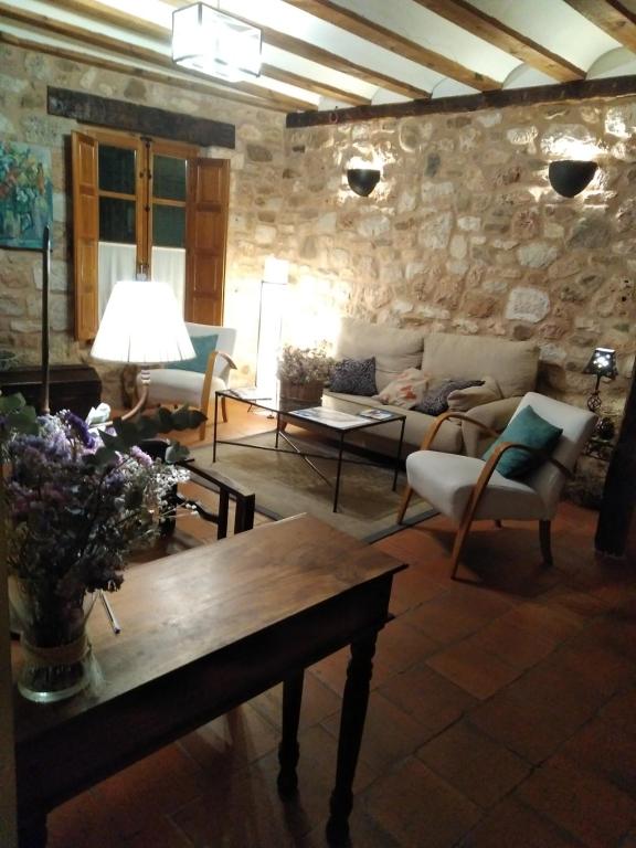 Hotel Rural El Adarve في أيلون: غرفة معيشة مع أريكة وطاولة