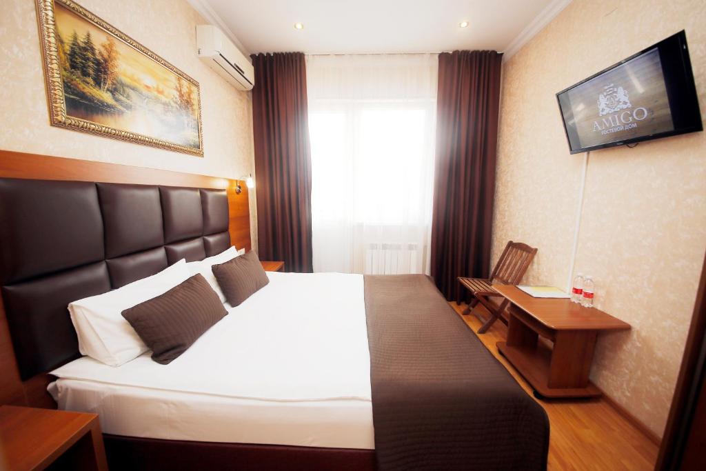 Cette chambre comprend un grand lit et une fenêtre. dans l'établissement AMIGO Tuapse, à Touapsé