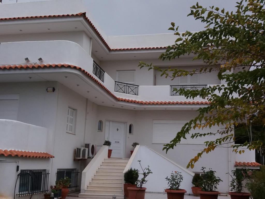 a white house with stairs and plants on it at Beach House Villa in Nea Makri