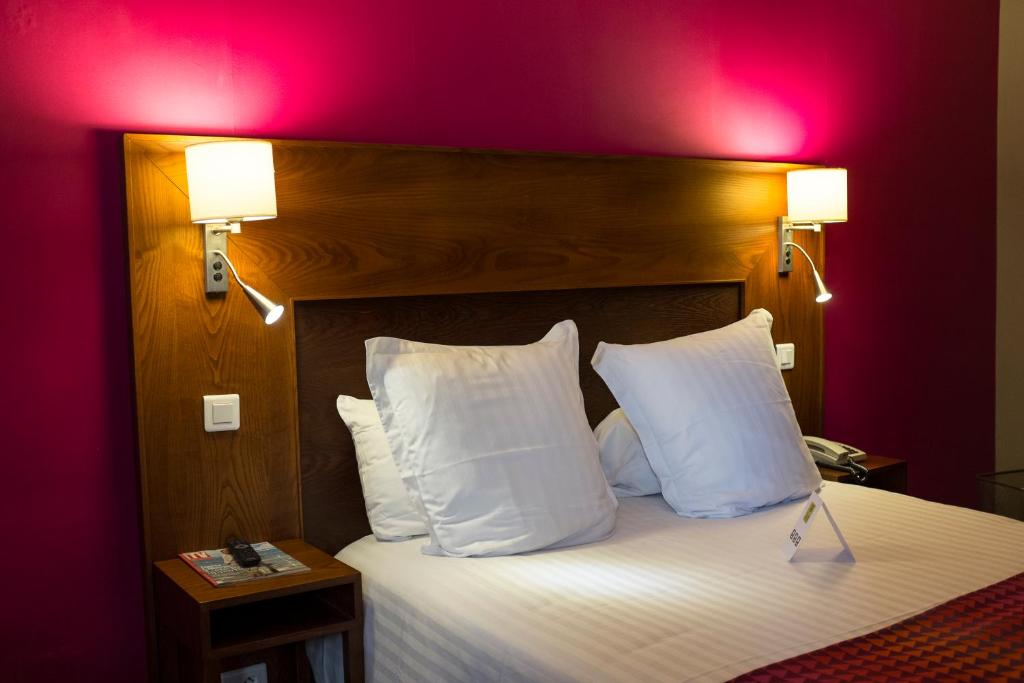 Le Nouvion-en-Thiérache的住宿－Hotel Restaurant La Paix，一间卧室配有一张带两个白色枕头的大床