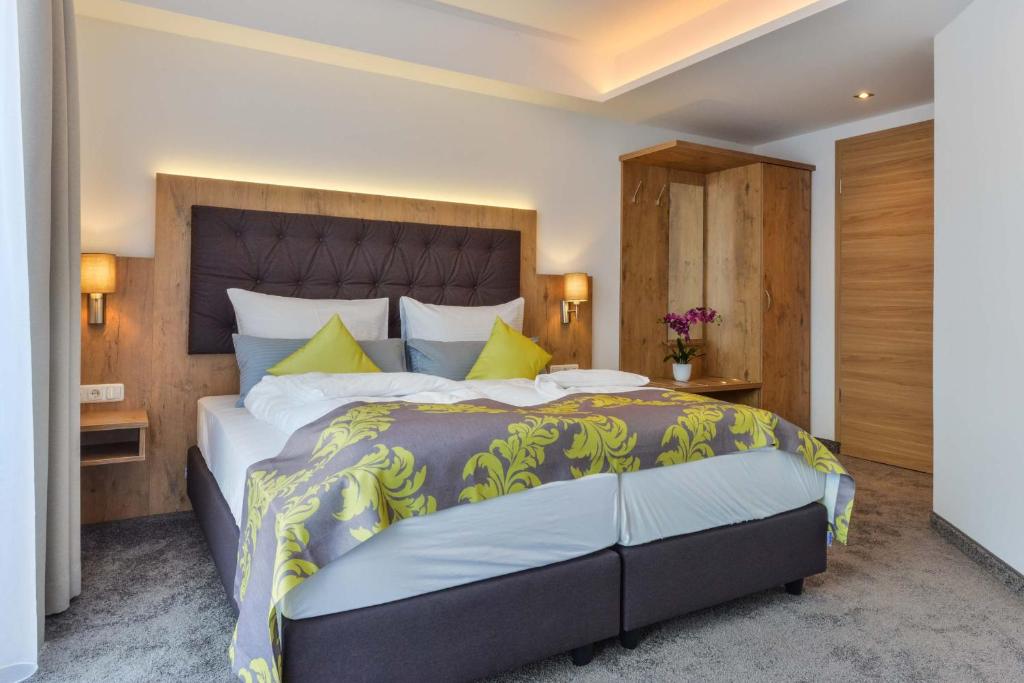 奧格斯堡的住宿－Hotel Haunstetter Hof Augsburg，一间卧室配有一张带黄色枕头的大床