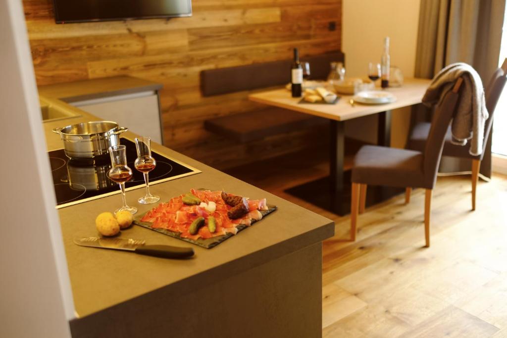 a plate of food on a counter with wine glasses at Unterlutaschg-Chalet Appartement am Hof in Slingia