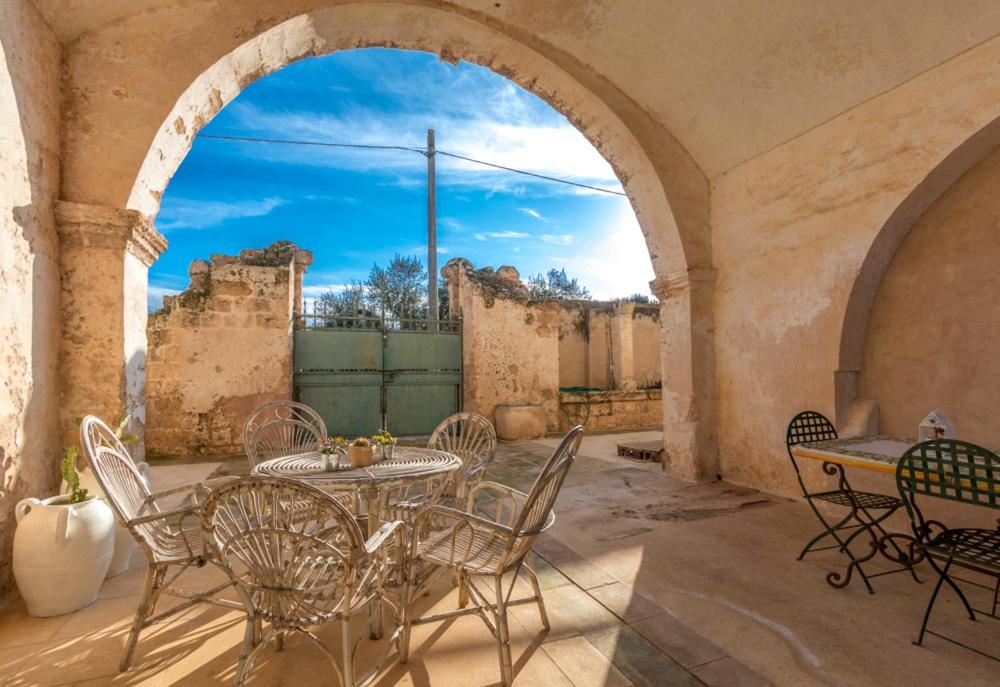 a patio with a table and chairs in a building at La Fragna in Nardò