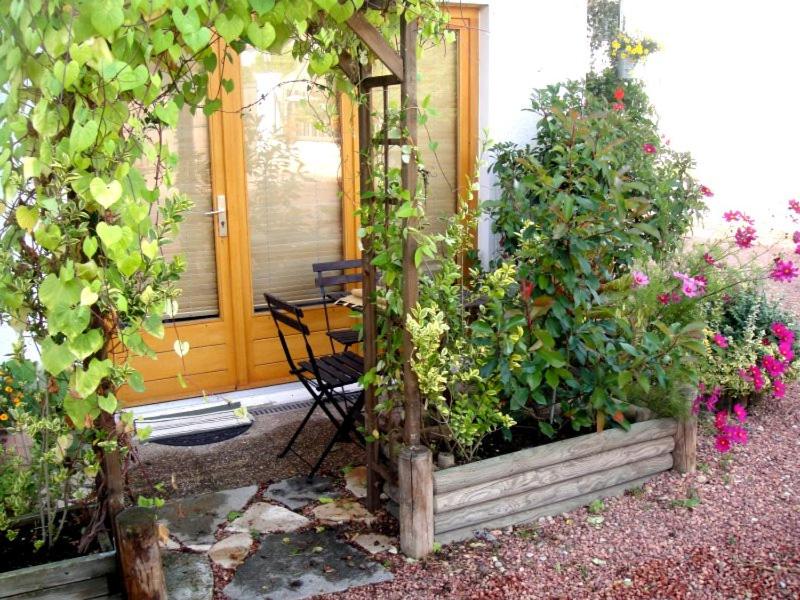 una casa con una mesa y algunas plantas y flores en Le Chantemerle climatisé, en Briennon