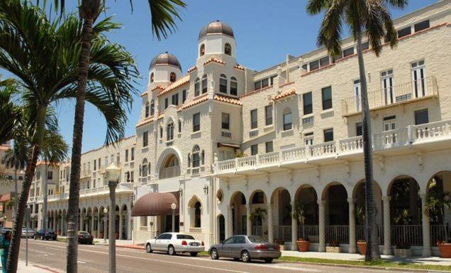 een groot wit gebouw met auto's geparkeerd voor het bij Tropical Palm Beach 2 Bedroom 2 Bathroom Suite POOL -BEACH 2 Blocks Valet Parking Included in Palm Beach