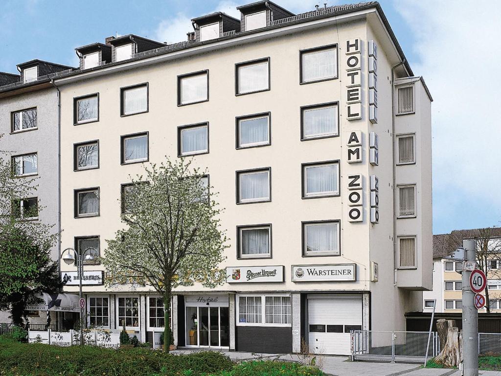 ein großes weißes Gebäude mit einem Schild drauf in der Unterkunft Hotel am Zoo in Frankfurt am Main