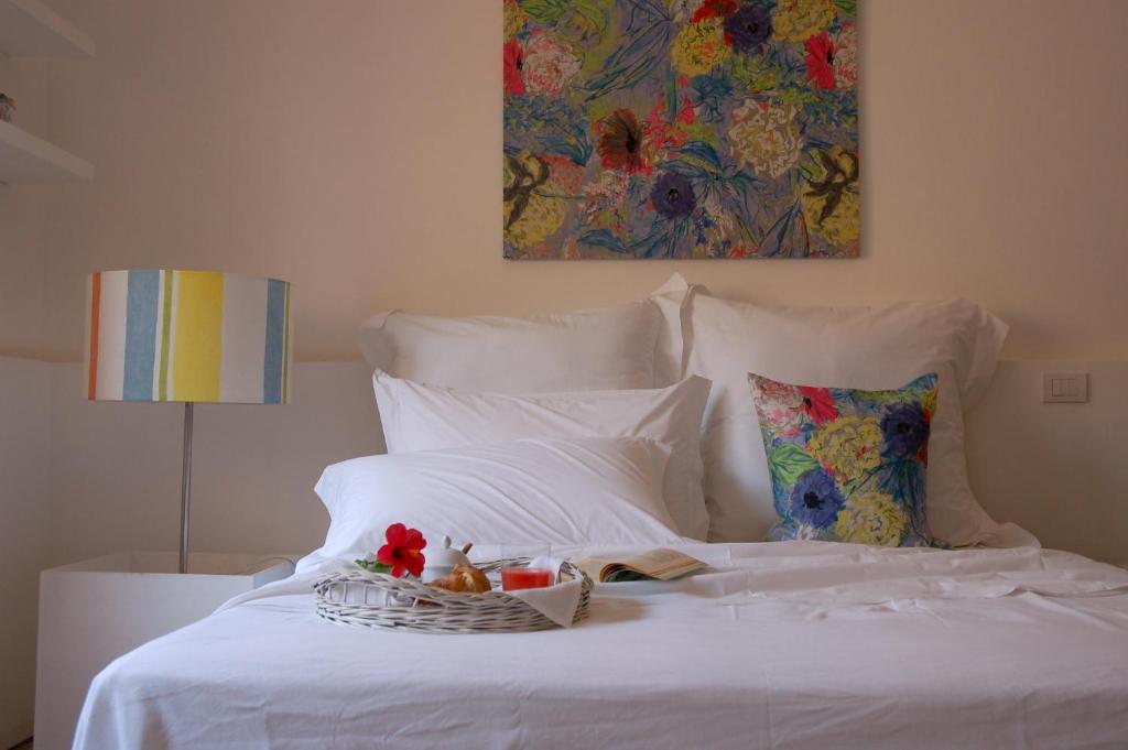a white bed with a basket of fruit on it at fuoridalgusciohome in Leuca