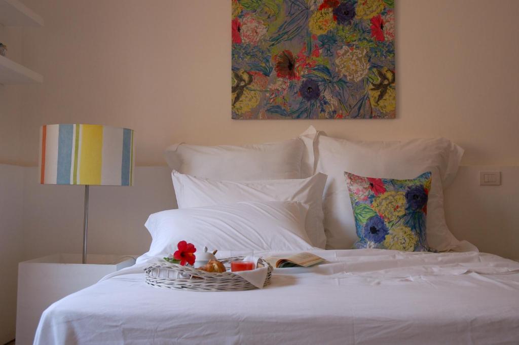 a white bed with a basket of fruit on it at Fuoridalguscio Home in Leuca