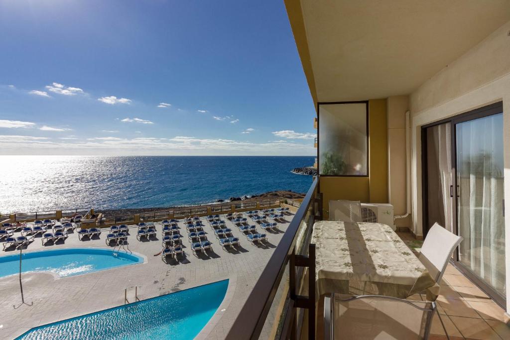 サンミゲル・デ・アボナにあるOne bedroom Ocean view Golf del Sur Apartamentのスイミングプールと海を望むバルコニー
