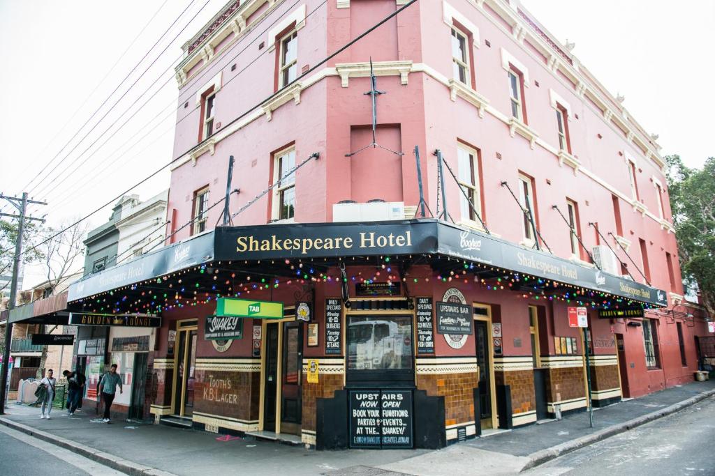 a pink building with a shakespeare hotel on a street at Shakespeare Hotel in Sydney