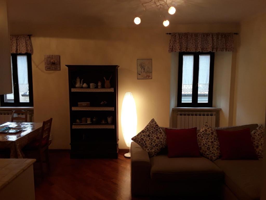 sala de estar con sofá, mesa y ventanas en Dentro le mura, en Rieti