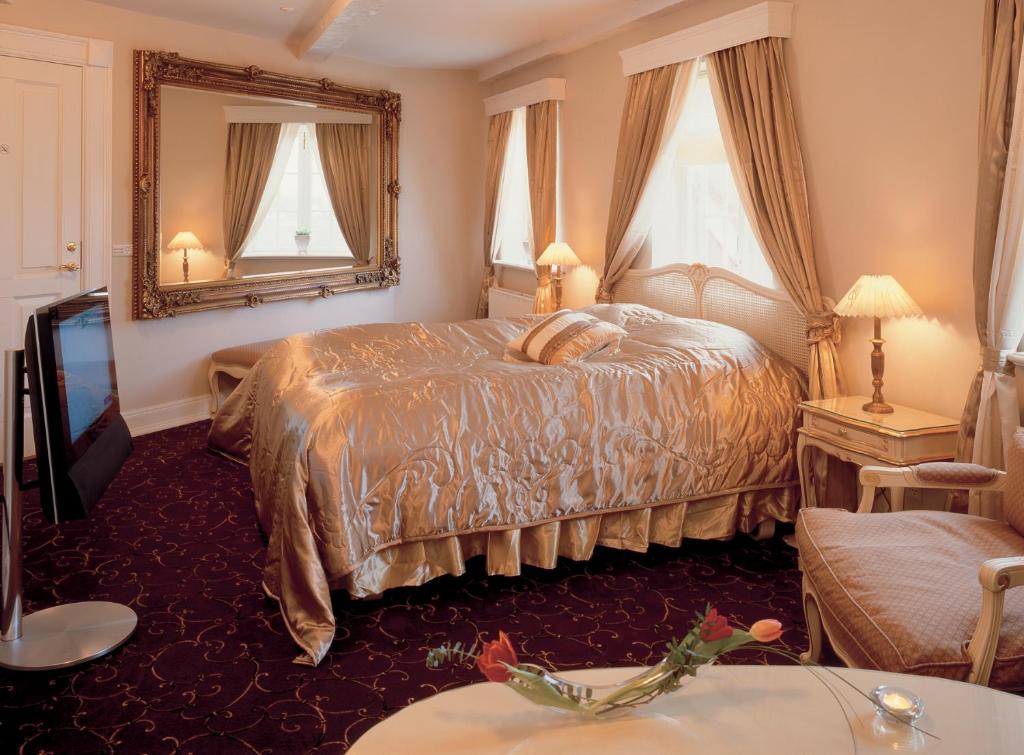 um quarto de hotel com uma cama e um espelho em Tyrstrup Kro em Christiansfeld