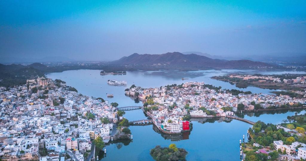 una vista aérea de una ciudad sobre un cuerpo de agua en Oolala - Your lake house in the center of Udaipur en Udaipur