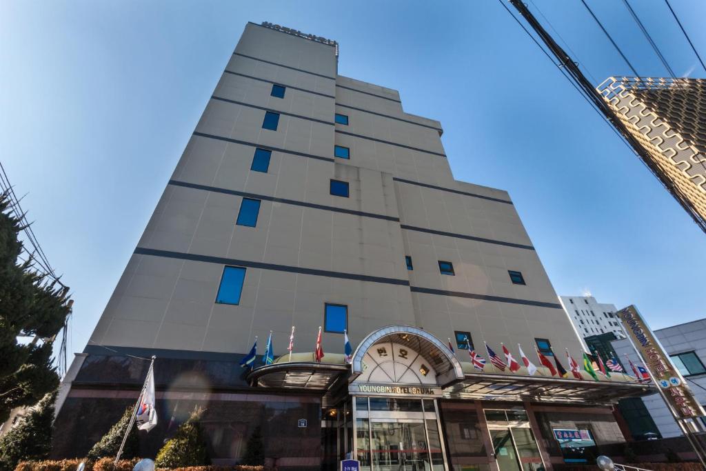 a tall building with flags in front of it at Youngbin Hotel in Seoul