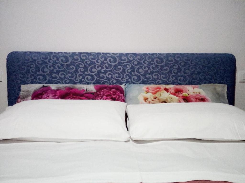1 cama con cabecero azul y 2 almohadas en B&B Casa San Jacopo al Giardino, en Lucca