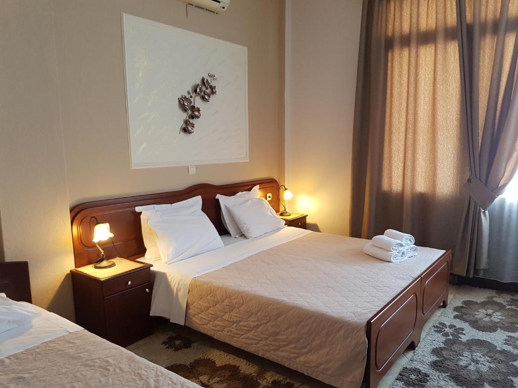 um quarto de hotel com duas camas e uma janela em Xenonas Arxontiko em Kato Loutraki