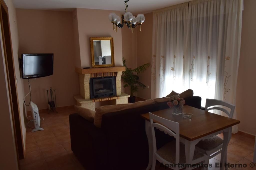 a living room with a couch and a table and a fireplace at Apartamentos Horno y Casa De Dulce in Purullena