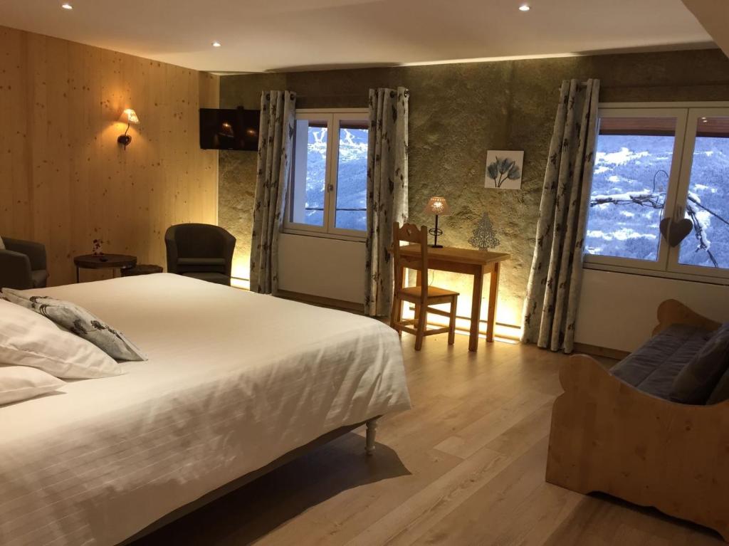 una camera con letto, scrivania e finestre di Le Coeur 1210 a Granier