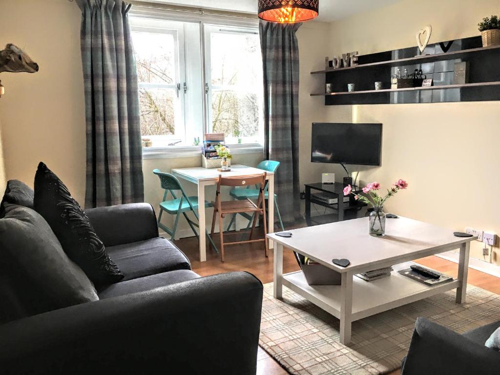 a living room with a couch and a table at Grassmarket, Castle Wynd Apartment in Edinburgh