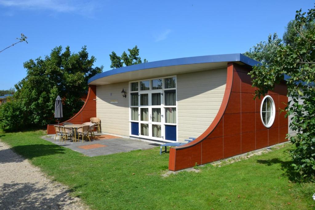 una pequeña casa con una mesa delante en Vlugtenburg, en s-Gravenzande